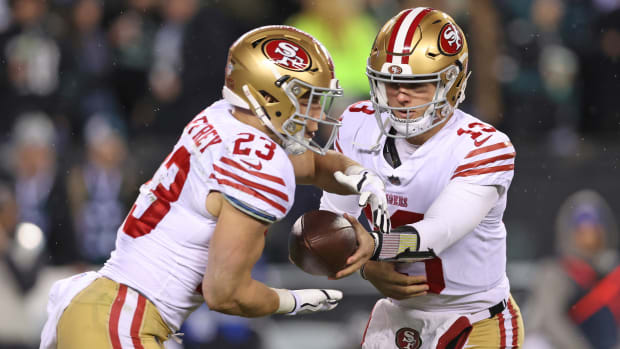 Brock Purdy passes off the ball to Christian McCaffrey